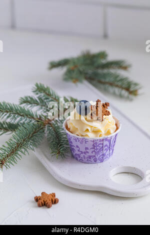 Tasty blueberry muffin with cream on white wooden table, Christmas dessert Stock Photo