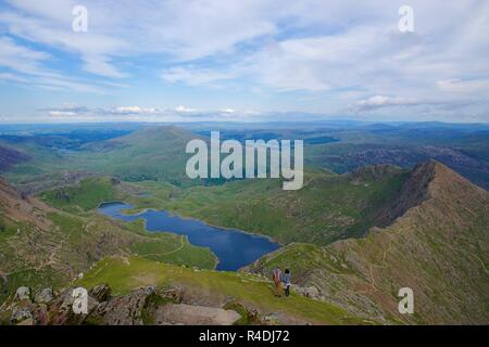 Couple gazing out over Snowdonia from the top of Snowdon Stock Photo