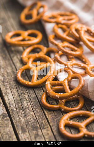 Salted mini pretzels snack on old wooden table. Stock Photo