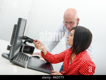 Young female designer and mature man using graphics tablet Stock Photo