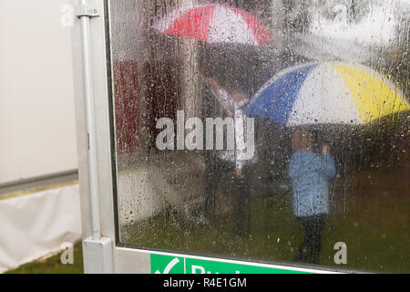 Umbrellas seen through rain-soaked window Stock Photo