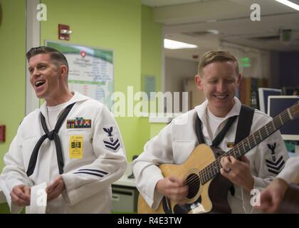 HOLLYWOOD, Fla. (May 2, 2017) Musician 2nd Class James Choate, left, and Musician 1st Class Trevor Shifflett, assigned to the Navy Region Southeast Band, perform for patients at the Joe DiMaggio Children’s Hospital during the 27th annual Fleet Week Port Everglades. Fleet Week Port Everglades provides an opportunity for the citizens of South Florida to witness first-hand the latest capabilities of today’s maritime services, and gain a better understanding of how the sea services support the national defense of the United States. Stock Photo