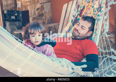 Portrait of a father and daughter lying on the hammock Stock Photo