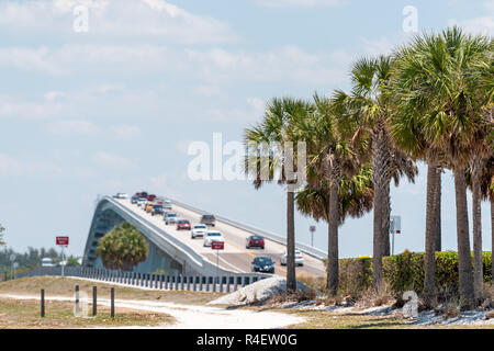 Sanibel Island, USA bay on beach during sunny day with toll bridge causeway bridge highway road and cars traffic, palm trees in holiday vacation desti Stock Photo
