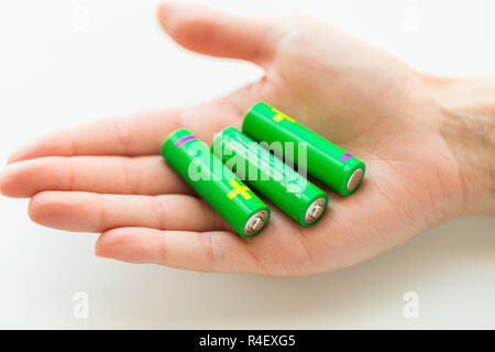close up of hand holding green alkaline batteries Stock Photo