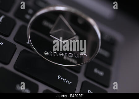 Silver ethereum coin is lying on laptop Stock Photo