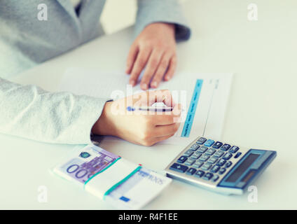 close up of hands counting money with calculator Stock Photo