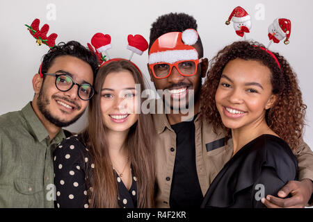 Four friends in funny New Year accessories. Stock Photo