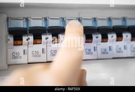 Male hand switching off fuse board. Stock Photo