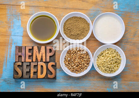 collection of hemp seeds and related  products: hearts, protein powder, milk and oil in small white bowls with a text in vintage letterpress wood type Stock Photo