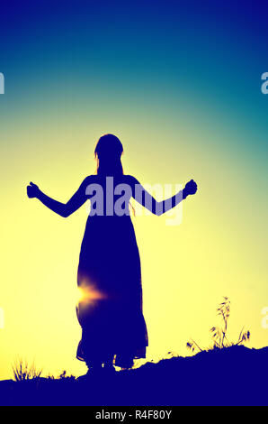 woman silhouette in front of a sunset Stock Photo