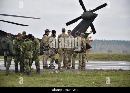 Multinational soldiers listen to a safety briefing before they conduct the High Angle Shot lane during the European Best Sniper Squad Competition at the 7th Army Training Command’s, Grafenwoehr Training Area, Bavaria, Germany, Oct. 24, 2016. The European Best Sniper Squad Competition is an Army Europe competition challenging militaries from across Europe to compete and enhance teamwork with Allies and partner nations. Stock Photo