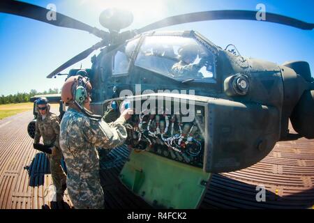 Soldiers assigned to 1st Attack Reconnaissance Battalion, 82nd Combat Aviation Brigade, loads multiple 30 mm rounds into the M230 Chain Gun attached to the undercarriage of an AH-64D Apache helicopter at a Forward Arming Refuel Point on Fort Bragg, N.C., May 2. Stock Photo