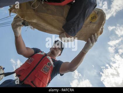 Crew members from Coast Guard Cutter Tarpon, an 87-foot Coast Patrol Boat homeported in St. Petersburg, Florida, offload 1,735 kilograms of cocaine, an estimated wholesale value of $56 million and transfer custody of eight suspected drug smugglers Wednesday, May 3, 2017 at Coast Guard Sector St. Petersburg, Florida. The contraband and suspected smugglers were interdicted during four separate cases supporting Operation Martillo, a joint interagency and multi-national collaborative effort among 14 Western Hemisphere and European nations to stop the flow of illicit cargo by Transnational Criminal Stock Photo