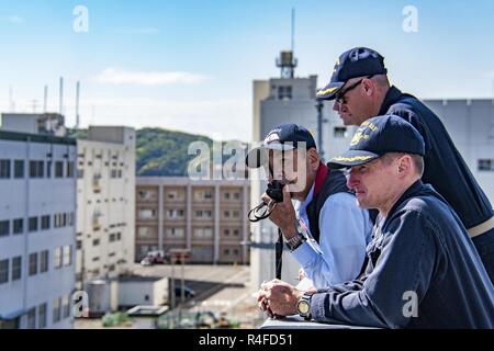 SASEBO, Japan (May 4, 2017) Capt. Thomas Shultz, executive officer of the amphibious transport dock USS Green Bay (LPD 20), observes the ship returning pierside to its forward-deployed base of Sasebo, Japan after completing a Mid-Cycle Inspection (MCI) rehearsal. Green Bay, assigned to Commander, Amphibious Squadron 11, conducted at-sea preparations for its upcoming MCI, which is conducted at the mid-year point prior to the Board of Inspection and Survey (INSURV) and is used to inspect and assess the material conditions of a ship. Stock Photo