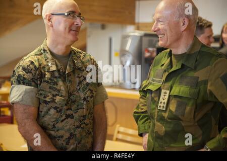 Admiral Haakon Bruun-Hanssen, the Norwegian Chief of Defense (right) speaks with U.S. Marine Corps Col. Doug Bruun, commander of the Marine Coordination Element with Marine Rotational Force Europe (MRF-E) 17.1, before a meeting at Værnes Garnison, Norway, May 4, 2017. The Chief of Defense, Minister of Defense, and other dignitaries ate at the chow hall while visiting the base to plan for Operation Powerful Maintenance. MRF-E supports our NATO Allies and partners in the Nordic region through military-to-military training. Stock Photo