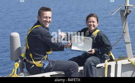 MEDITERRANEAN SEA (May 3, 2017) Information Systems Technician 2nd Class Nikki Duffy, from Bremerton, Washington, right, receives her certificate of discharge from Lt. Cmdr. Ben McCarty, from Erie, Pennsylvania, during a reenlistment on the yardarm of the Arleigh Burke-class guided-missile destroyer USS Ross (DDG 71) May 3, 2017. Ross, forward-deployed to Rota, Spain, is conducting naval operations in the U.S. 6th Fleet area of operations in support of U.S. national security interests in Europe and Africa. Stock Photo