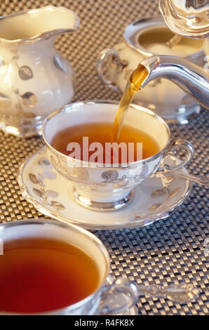Pouring hot tea for an elegant tea service Stock Photo