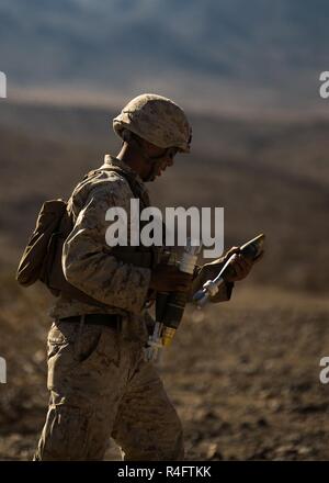 U.S. Marine Corps Pfc. Tanner J. Linn, mortarman, Bravo Company, 1st Battalion, 2nd Marine Regiment, carries 60mm mortars while conducting final protective fires during the mechanized assault course in Twentynine Palms, Calif., Oct. 25, 2016. Bravo Company is participating in Integrated Training Exercise (ITX) 1-17 and preparing to support Special Purpose Marine Air-Ground Task Force. Stock Photo