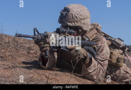 Pfc. Elmer Perez, a scout rifleman with 1st Light Armored Reconnaissance Battalion, 1st Marine Division, takes up a firing position during a field exercise aboard Marine Corps Base Camp Pendleton, Calif., Oct. 25, 2016.  The exercise was held as part of a week-long Marine Corps Combat Readiness Evaluation. Marines undergo MCCREs to ensure combat readiness before deployments. This training allows Marines to become proficient and comfortable with their weapon systems in a realistic environment. Stock Photo