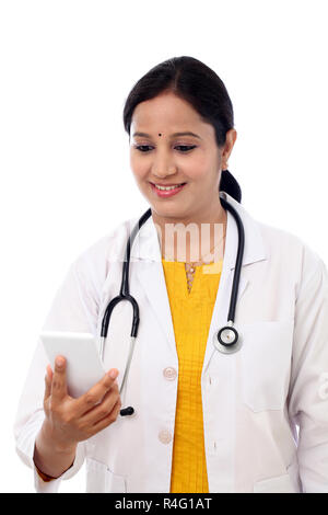 Female doctor looking text message on cellphone Stock Photo