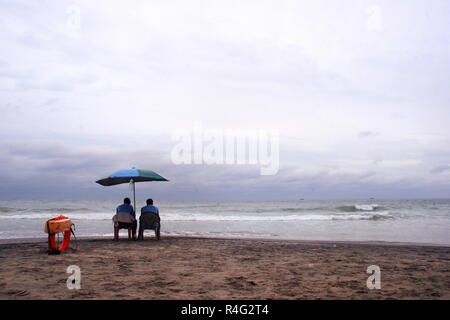 Two men sitting on chair at beach Stock Photo