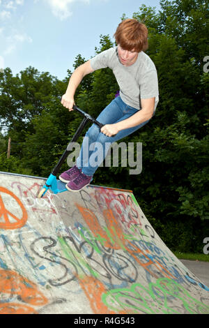 young boy going airborne with a scooter Stock Photo