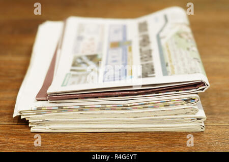 Pile of fresh morning newspapers on table at office. Latest financial and business news in daily paper. Pages with data. Folded and stacked journals Stock Photo