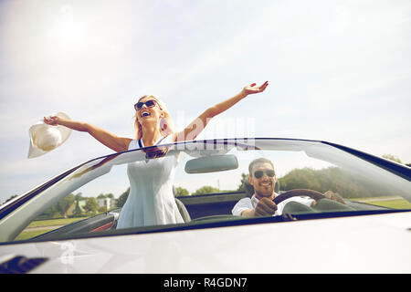 happy man and woman driving in cabriolet car Stock Photo