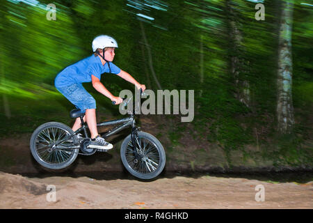 child has fun jumping with thÃ© bike over a ramp Stock Photo