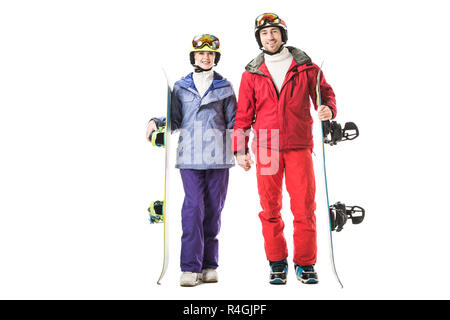 couple in ski clothes with snowboards holding hands and looking at camera isolated on white Stock Photo