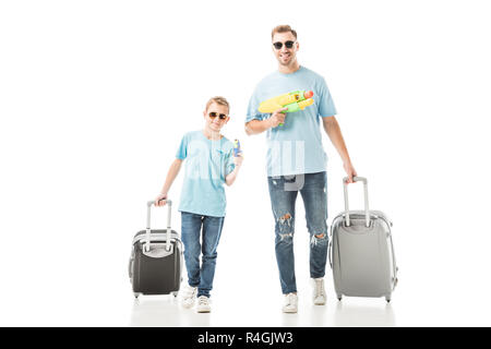 Dad and son walking with luggage and holding water guns isolated on white Stock Photo