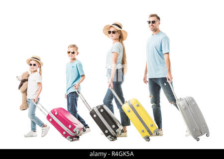 Happy family walking with colourful luggage and smiling isolated on white Stock Photo