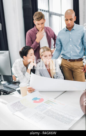 focused young multiethnic coworkers working with business charts in office Stock Photo