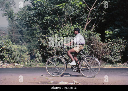 School boy riding bicycle on road, Kolhapur, Maharashtra, India, Asia Stock Photo