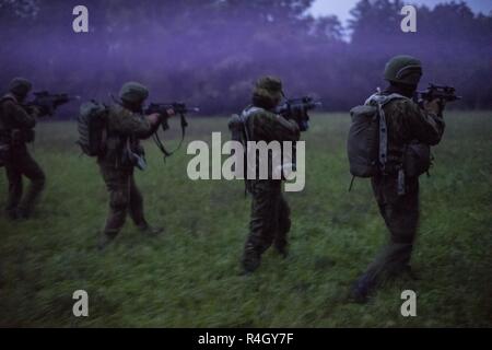 Members of the the Lithuanian National Defence Volunteer Forces (KASP) move across an objective during exercise Saber Junction 2018 at the Joint Multinational Readiness Center in Hohenfels, Germany, September 22, 2018. The KASP worked alongside U.S. special operations forces during Saber Junction 18 to conduct irregular warfare in enemy occupied territory to support the U.S. Army’s 173rd Airborne Brigade as they executed land operations in a multinational joint environment. Stock Photo