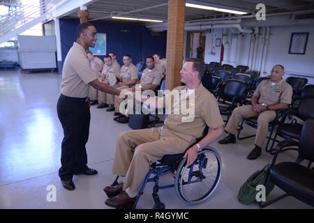 GREAT LAKES, Ill (September 27, 2018) Electronics Technician 2nd Class Christian Chen, staff at Center for Surface Combat Systems Unit Great Lakes, receives a command from Naval Education and Training Command Commander Rear Adm. Kyle Cozad Sept. 27. Stock Photo