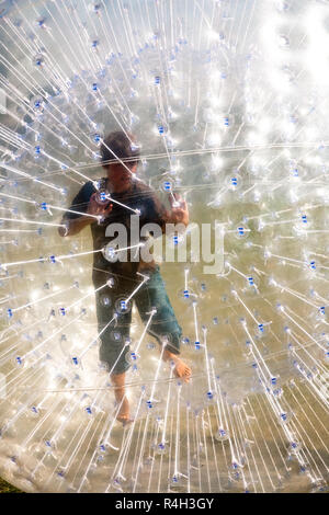 cute child has a lot of fun in the Zorbing Ball Stock Photo