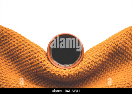 Cup of coffee wrapped in mustard scarf. Stock Photo