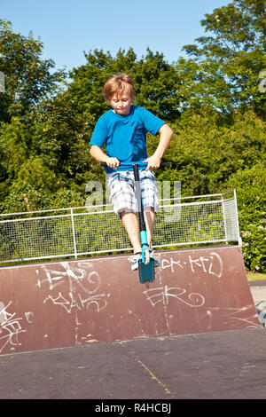 young boy going airborne with a scooter Stock Photo