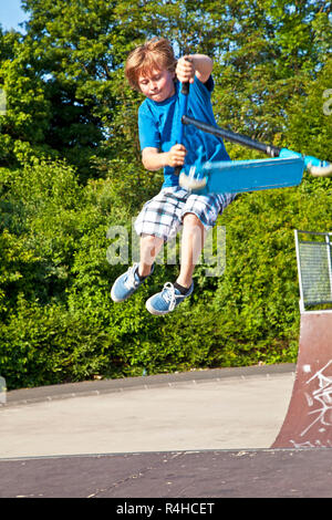 young boy going airborne with a scooter Stock Photo