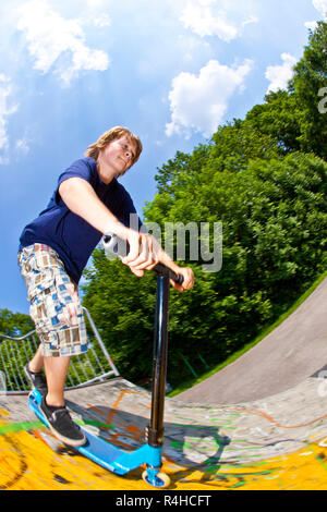 young boy going airborne with a scooter Stock Photo