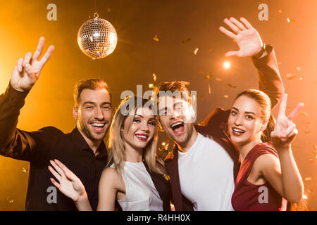 group of happy friends looking at camera and gesturing during party Stock Photo