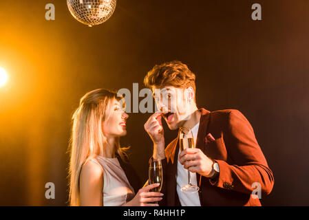 happy young couple with champagne having fun during party under golden light Stock Photo