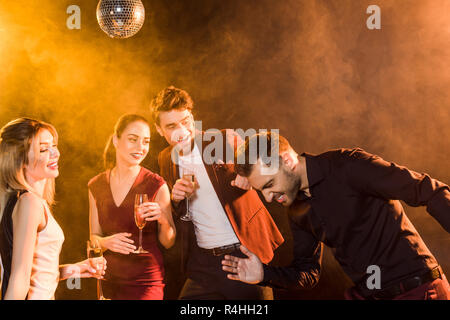 group of friends having fun together on party under golden light Stock Photo