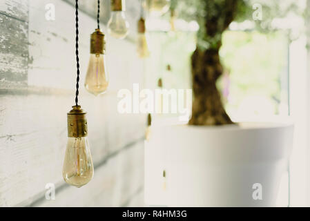Elongated decoration bulbs hanging from the wooden ceiling. Stock Photo