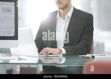 close up.Young man working with a laptop, a human hand on the notebook Stock Photo