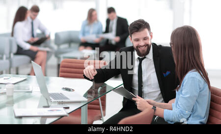 business couple discussing working paper sitting at Desk Stock Photo
