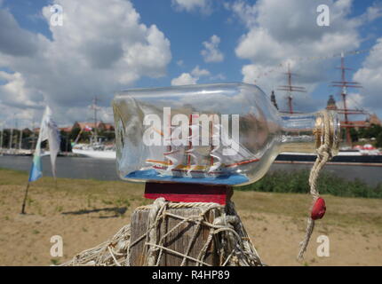 sailcloth ship in closed with cork bottle on harbor background Stock Photo