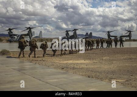 U.S. Marines with Charlie Company, 1st Battalion, 3rd Marine Regiment, prepare to embark on MV-22B Osprey aircraft in support of an assault support tactics exercise during Weapons and Tactics Instructor (WTI) course 1-19 at Laguna Army Airfield, Yuma, Arizona, Oct. 3, 2018. WTI is a seven-week training event hosted by Marine Aviation Weapons and Tactics Squadron One (MAWTS-1) which emphasizes operational integration of the six functions of Marine Corps aviation in support of a Marine air-ground task force. WTI also provides standardized advanced tactical training and certification of unit inst Stock Photo